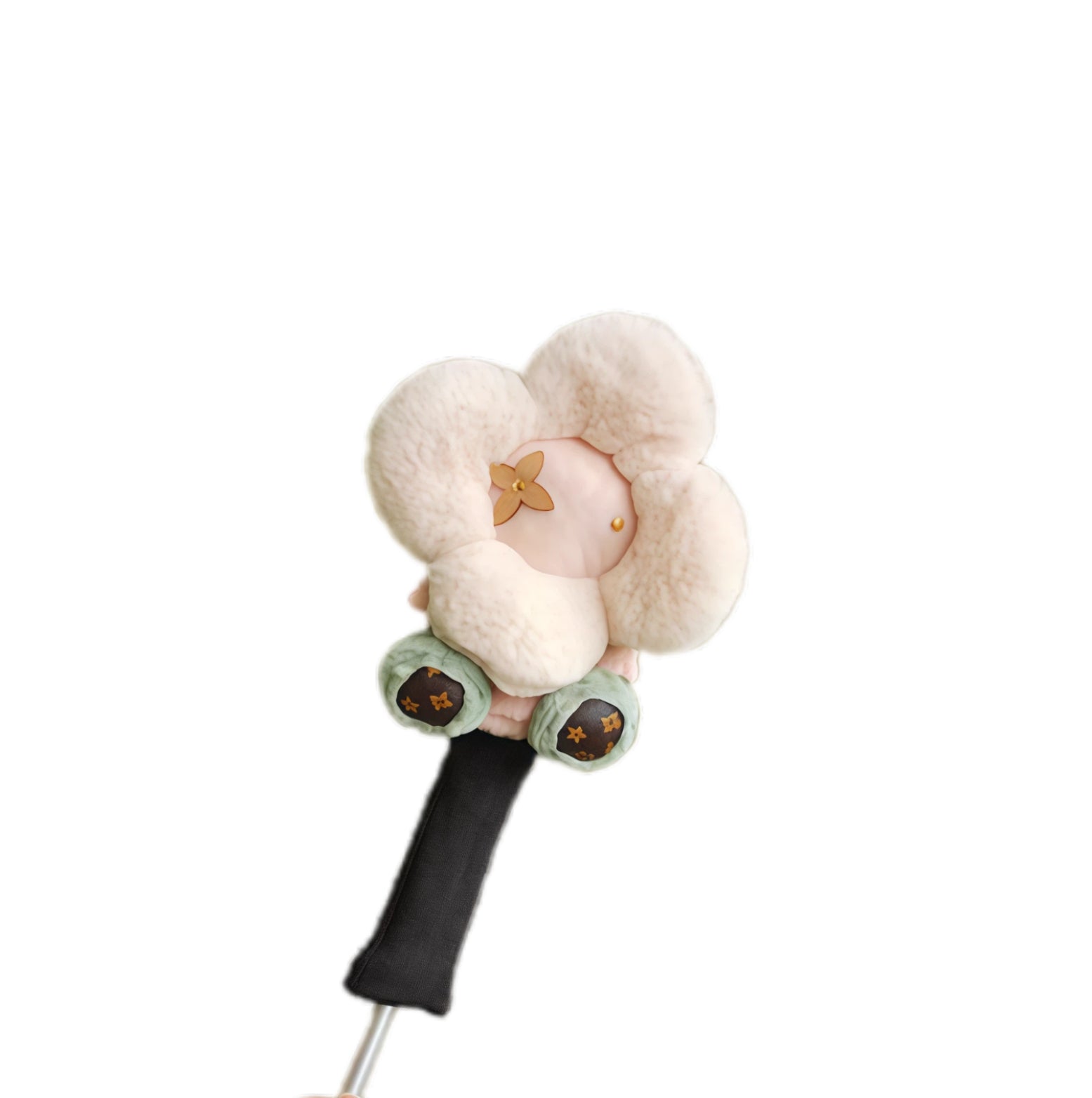 Cream plush flower-shaped golf driver headcover with five fluffy petals and small brown monogram detail, fitted on a club