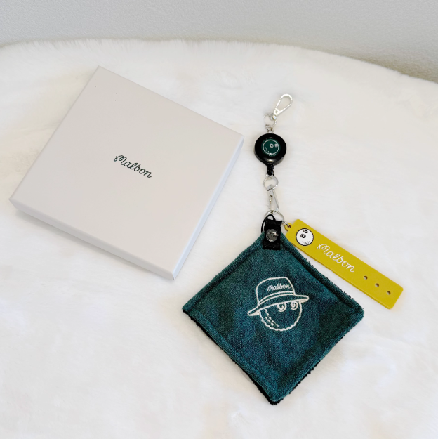 Malbon Golf Towel & Keychain Gift Set 2026 — cleaning a golf ball