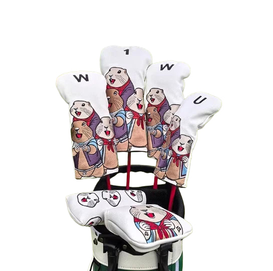 Full view of a white marmot golf headcover set including driver, fairway wood, hybrid, and putter covers, each featuring cheerful cartoon marmots in red scarves, displayed upright in a golf bag.
