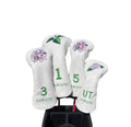 White GURUISI golf headcover set with delicate embroidered cherry blossoms and roses — includes numbered driver (1), 3-wood, 5-wood, and UT cover with magnetic fit and brand logo for stylish club protection.