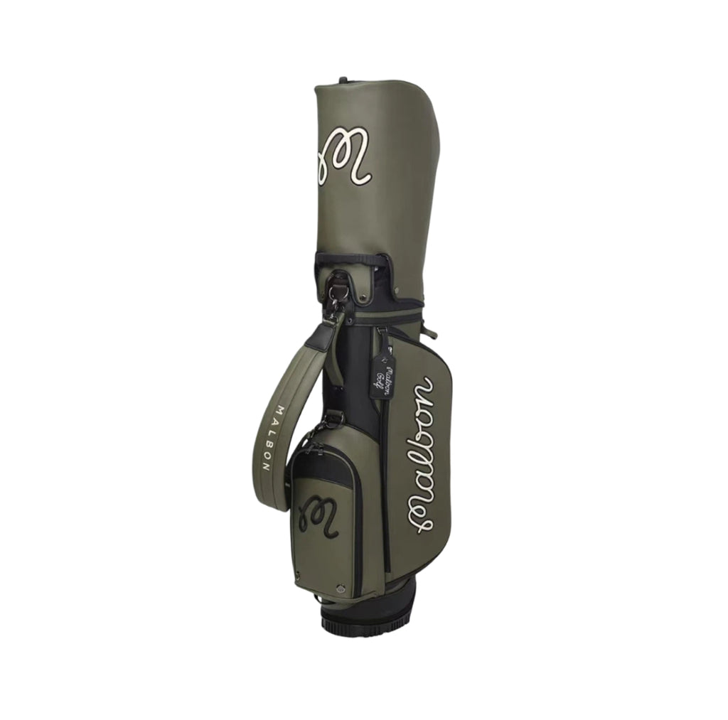 Side view of Malbon golf caddy bag showcasing durable PU leather construction, water-resistant material, side pockets, and brand name "Malbon" in script font.