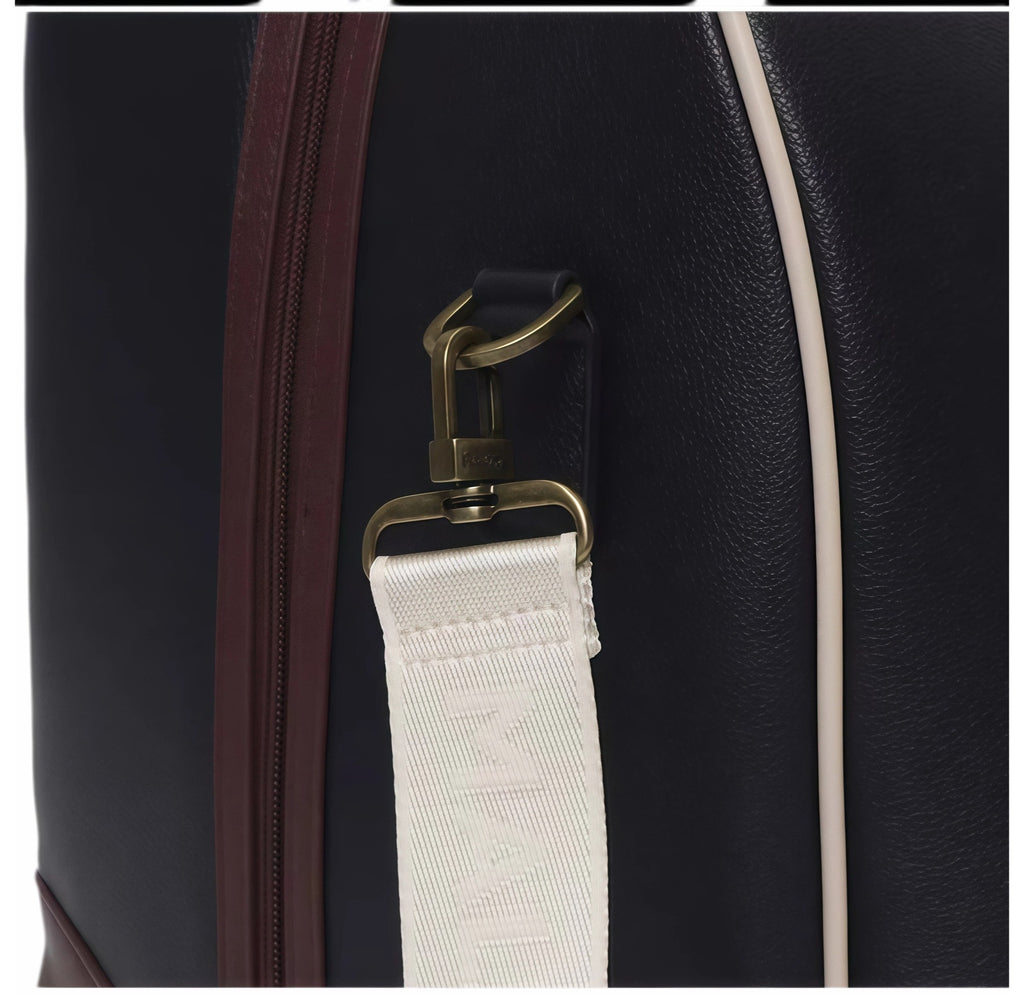 Detail shot of Malbon Golf duffle bag showing durable adjustable shoulder strap with woven "MALBON" text, brass-tone metal D-ring clasp, and high-quality PU leather stitching
