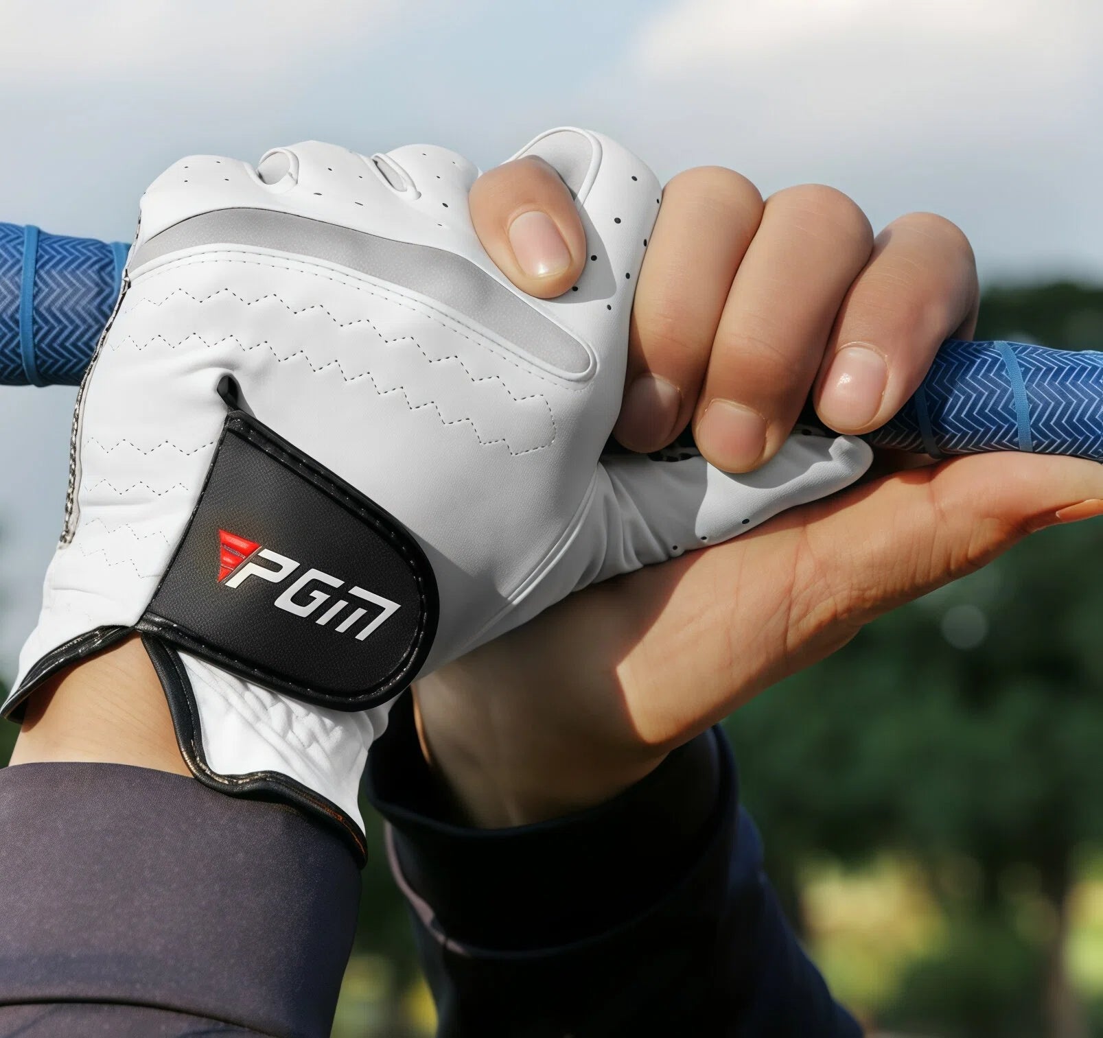 A golfer wearing the white PGM leather glove demonstrates a secure interlocking grip on a golf club. The glove provides a comfortable and stable feel, enhancing performance and control during a swing.