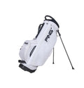 Side view of the PING Hoofer Lite Stand Bag in white. Features the large "PING" logo, built-in stand legs, padded top handle, and reinforced base. Designed for lightweight performance and easy carry.
