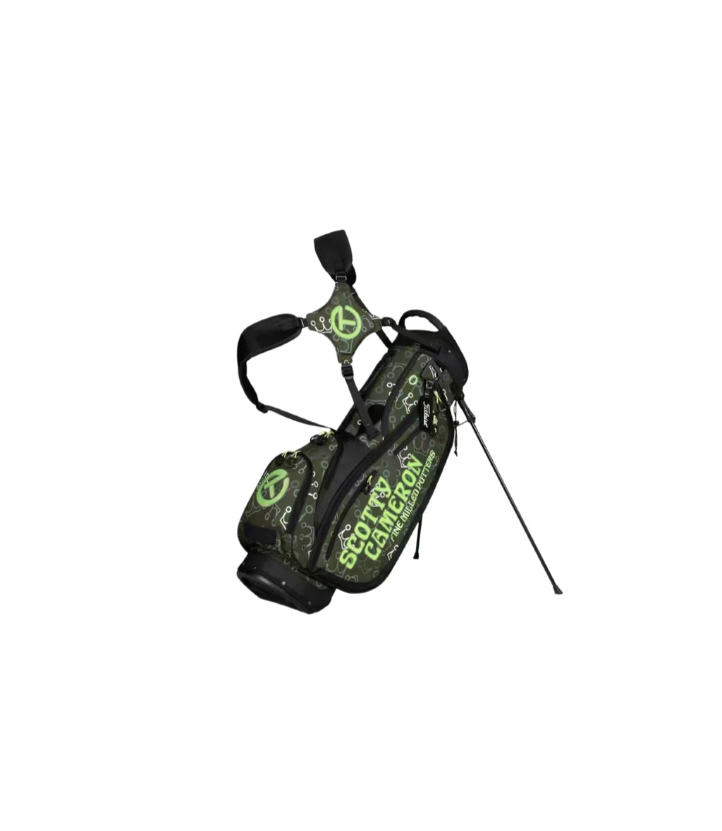 Angled view of the Scotty Cameron Pathfinder Stand Bag featuring a dark grey base with a repeating Mini Crown pattern in black and neon green, "SCOTTY CAMERON FINE MILLED PUTTERS" text, and a black dual strap system with a green Circle T logo.