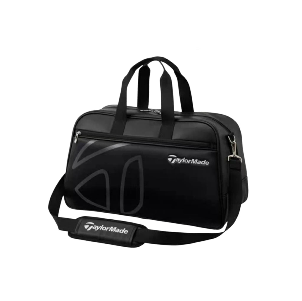 Front view of the TaylorMade Auth-Tech Boston bag in black featuring dual top handles, adjustable shoulder strap, and subtle embossed logo design. Made from durable water-resistant fabric with zippered compartments for organized storage of golf gear, apparel, and accessories.