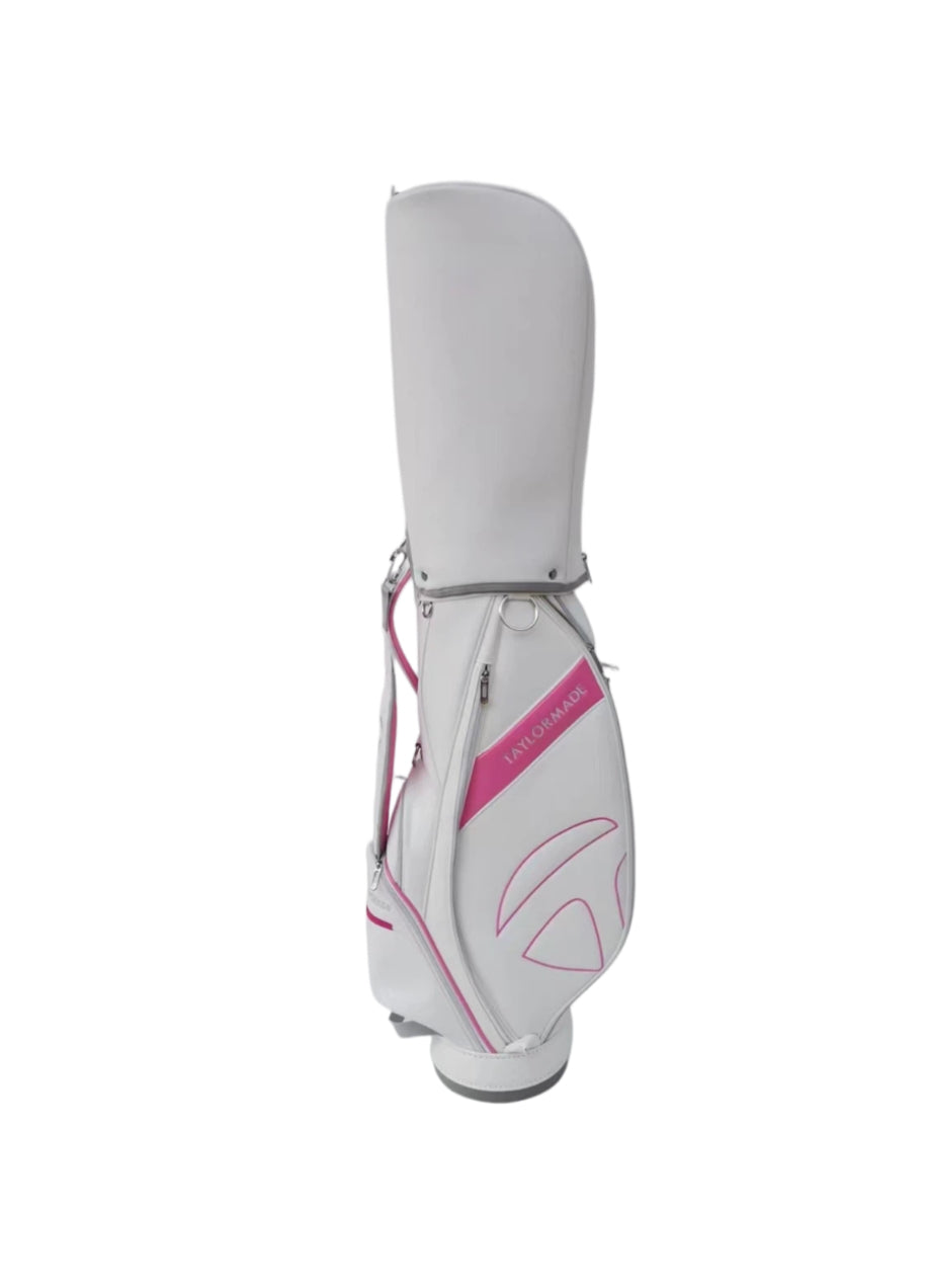 Full front view of the TaylorMade Concept One golf cart bag in white with pink detailing and a bold "TAYLORMADE" logo. Includes a padded shoulder strap, zippered pockets, and a sleek silhouette perfect for women golfers or those who prefer vibrant colors.